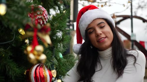Young Woman in Santa Hat by Christmas Tree