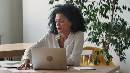 Woman Video Conferencing at Desk in Modern Office
