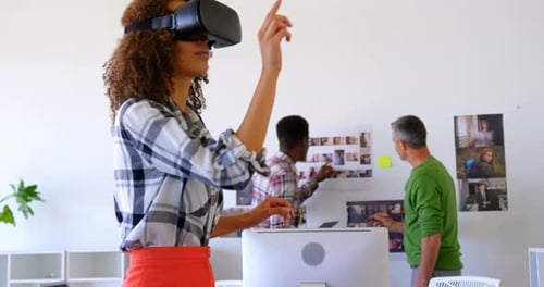Pretty mixed-race female executives using virtual reality headset in modern office 4k