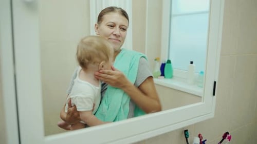 Mother Holding Her Baby in Bathroom