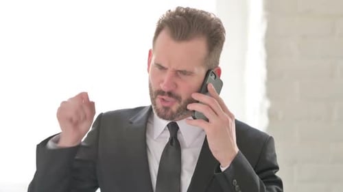 Upset Businessman Arguing on his Mobile Phone