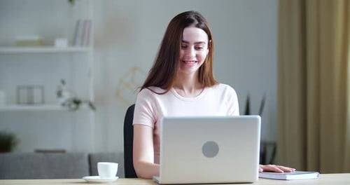 Woman Works at Computer in Home Setting