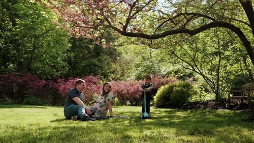 Happy Family Relaxing in a Beautiful Spring Park
