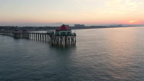 A stunning 4k View of the pier in Surf City USA at sunrise as tourists and people on vacation enjoy