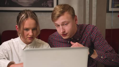 Young Adults Working on Laptop at Table