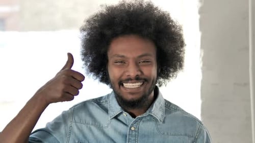 Thumbs Up By Young African Man Looking at Camera