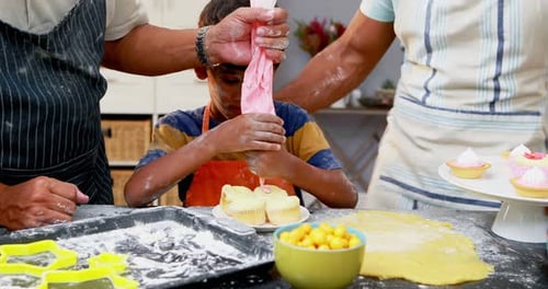 Großvater und Vater helfen Jungen beim Zubereiten von Cupcakes 4k
