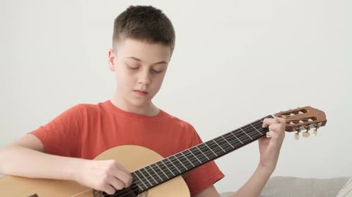 Teen Boy Plays Classical Guitar at Home