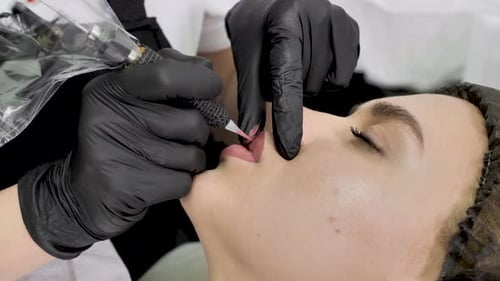 Eine Kosmetikerin schminkt die Lippen in einem Schönheitssalon permanent