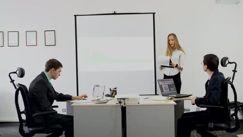 Businesswoman Presents Graph to Colleagues in Office