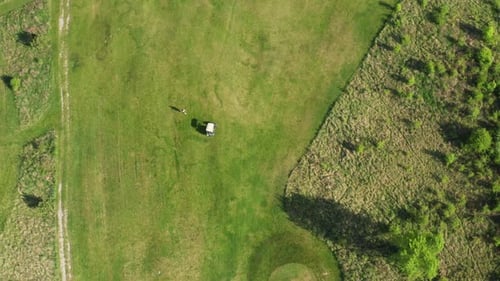 Person and Cart on Green Area Prepared for Playing Golf