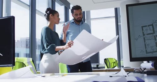 Architectural Colleagues Reviewing Blueprints in an Urban Office