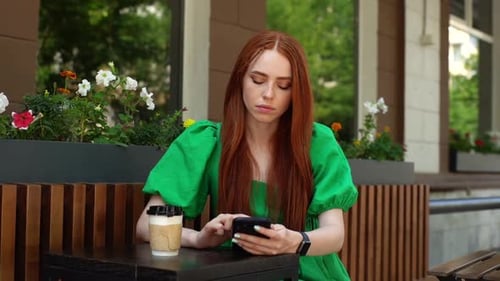 Young Woman Using Smartphone at Urban Cafe