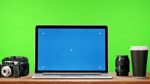 Laptop with Blue Chroma Key on Green Background Closeup Old Retro Photo Camera and Coffee Cup