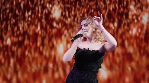 Blonde Woman Performing with Microphone on Stage