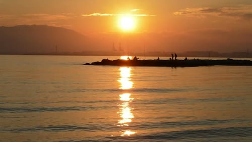 Sunrise Silhouette Fishing on Jetty Coastline