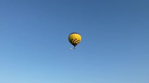 Bunte Heißluftballons fliegen am sonnigen morgendlichen blauen Himmel. Manövrierfähiger Flug. Reisen, Abenteuer,