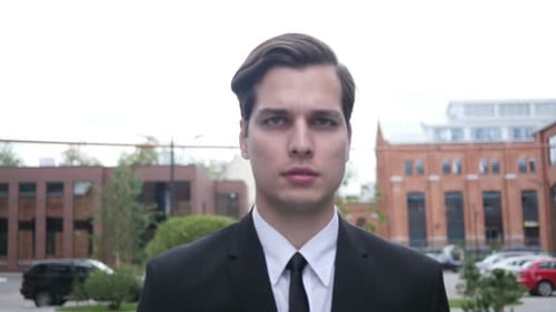 Young Adult in Suit Stands in Urban Setting