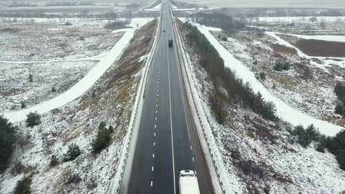 Winterautobahn-, Auto- und LKW-Verkehr. An den Seiten des Waldes.
