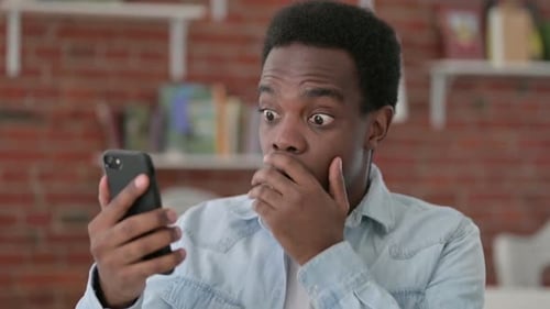 Man Reacts with Shock While Looking at Phone