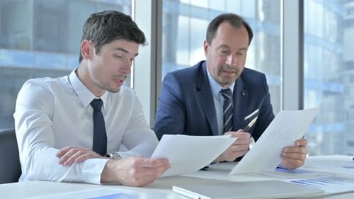 Business Meeting with Men Discussing Documents
