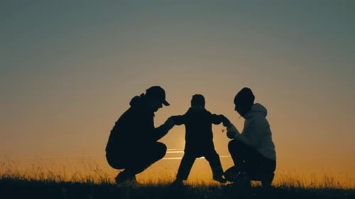 Family Silhouette Holding Hands at Sunset