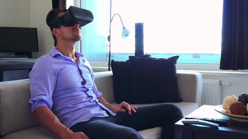 Man Relaxing with Virtual Reality Headset on Sofa