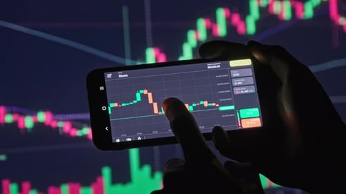 человек с телефоном смотрит на график криптовалют