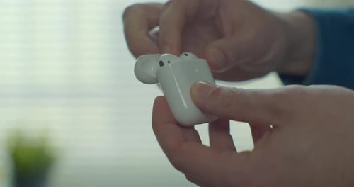 Close Up Man Takes Wireless Earphones From the White Case