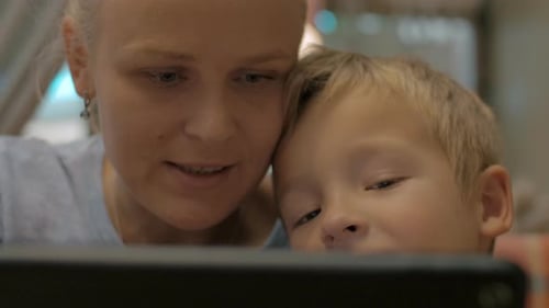 Woman and Child Looking at Tablet Device Together