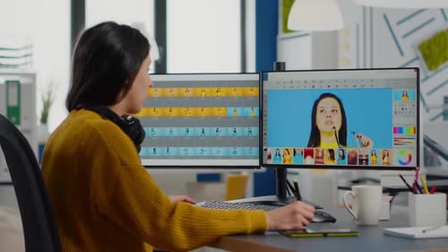 Woman Photo Editing with Dual Monitors in Office