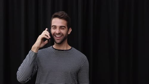 Man Celebrates Good News on Phone Call