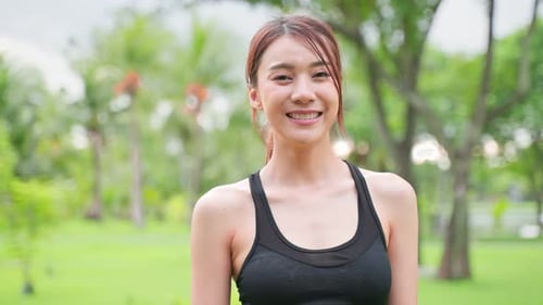 Portrait of Asian active sport woman stand with confidence after exercise outdoors at public park.