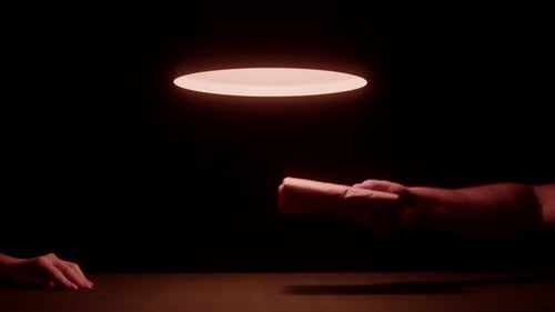 Hands Exchanging Wrapped Package on Table