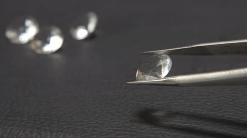 Clear Gemstone Held in Tweezers Close Up