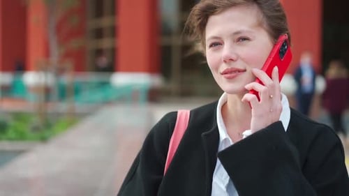 Cute Businesswoman Having Conversation on Smartphone Outdoors