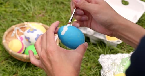 Decorating Easter Eggs for Holiday on Green Grass