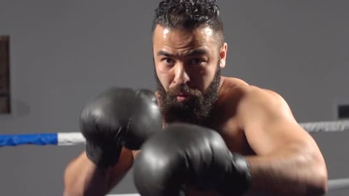 Bearded Man Practicing Punches in Boxing Ring