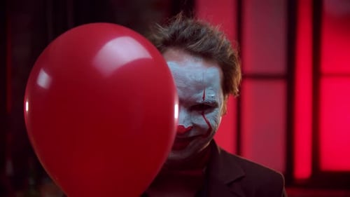 Un payaso aterrador que se asoma desde el globo rojo y una sonrisa espeluznante - Luz parpadeante intermitente