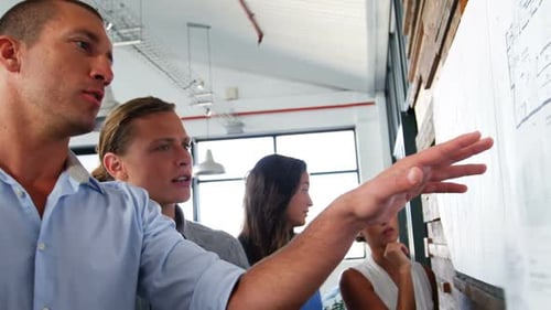 Team Collaborating on a Blueprint in Modern Office