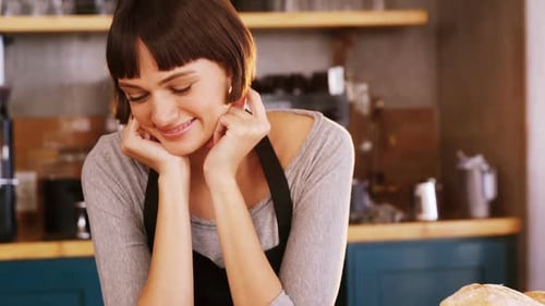 Bakery Worker Smiling in Front of Food Display