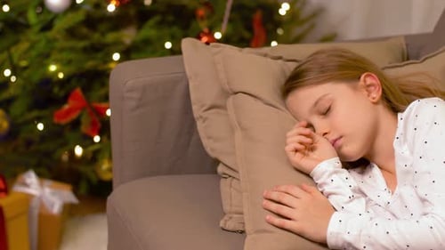 Girl Sleeping by Christmas Tree in Home