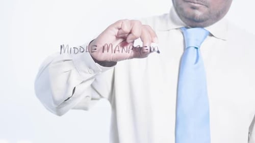 Man Writes 'Middle Management' on Clear Surface