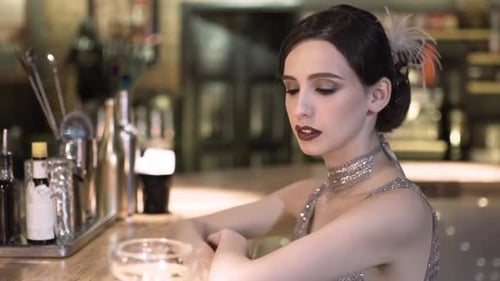 Closeup Portrait of a Young Attractive Woman in a 1920s Style Drink Wine or Champagne at the Bar