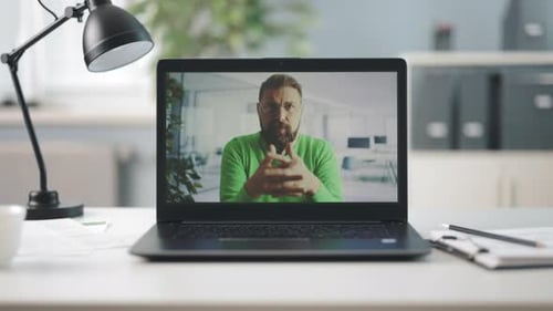 Man on Laptop Video Call in Bright Office