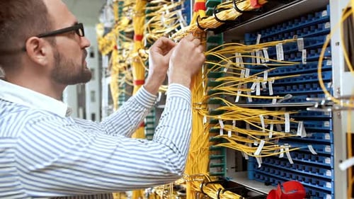 IT Technician Working with Server Cables in Data Center