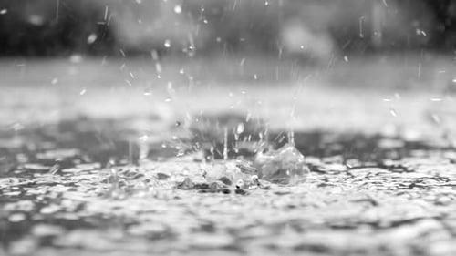 Close up view of rain drops on water in slow motion