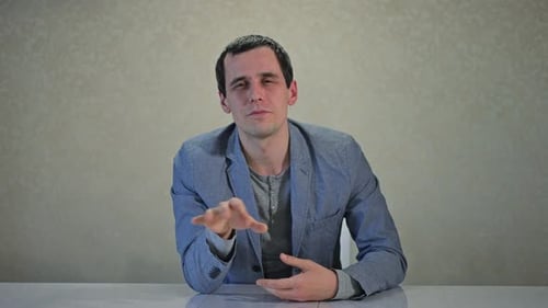 Smiling Man Talking at Desk Explaining