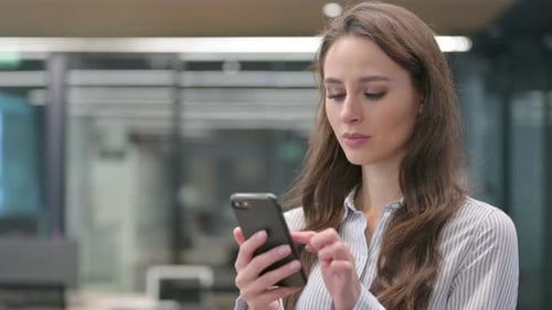 Confused Woman Using Phone in Modern Office