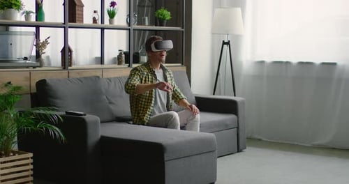 Man Using VR Headset on Gray Couch